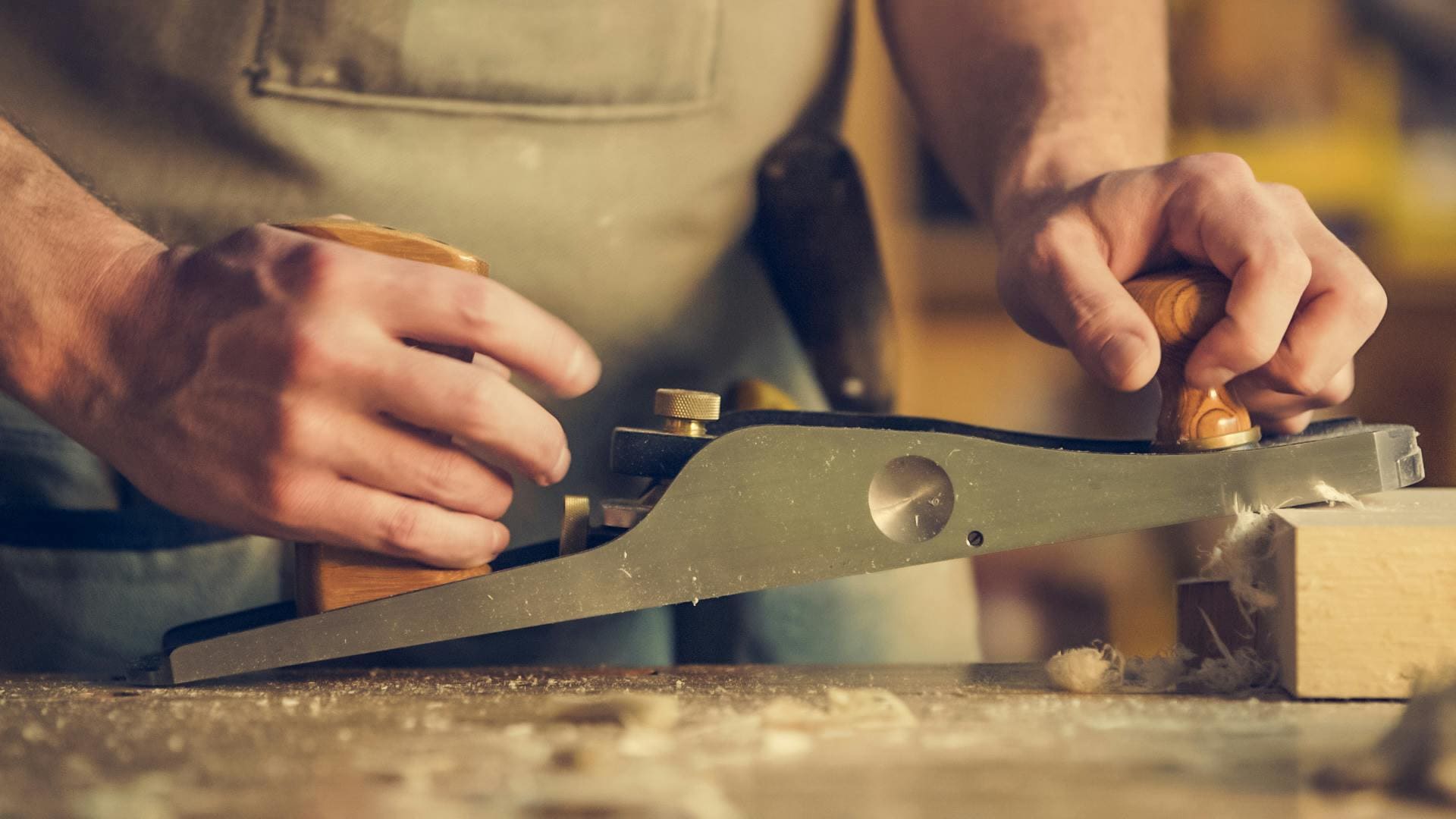 Woodworker planing a timber block
